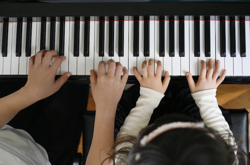 ピアノで連弾をする子供達